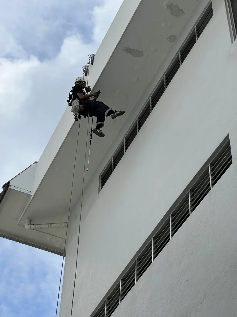 Rope access inspector checking high level facade scaled